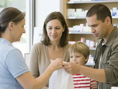 A couple at a pharmacy counter picking up a prescription for their young son.