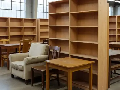 A showroom-style discounted furniture section with a few chairs, a side table and a bookshelf.